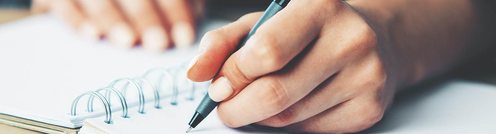 Close up of a hand writing in a notebook